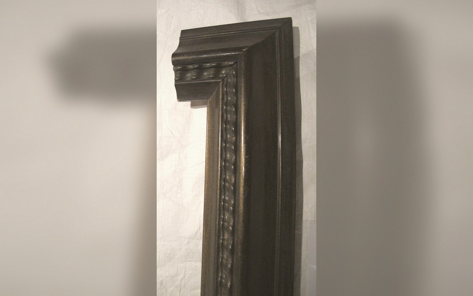 The corner of a gilded frame in raking light