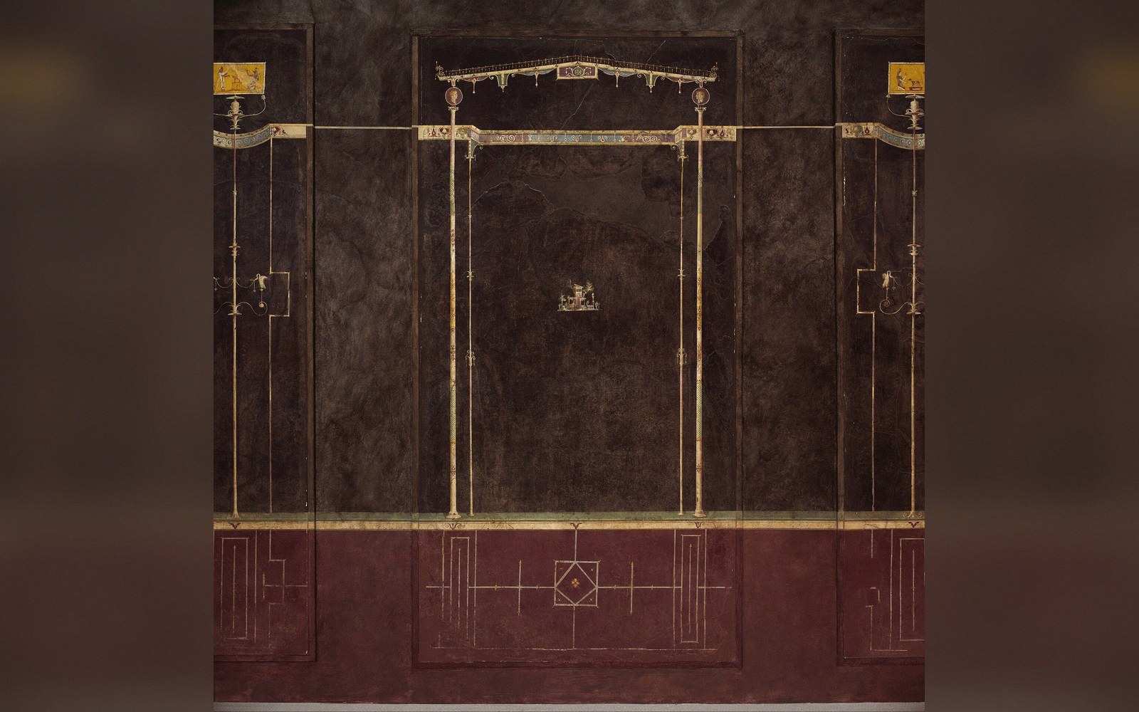 Ancient Roman fresco with black-ground panels, slender columns, and a small central landscape scene